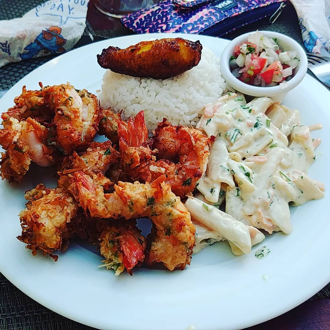 Coconut shrimp on plate with pasta. 