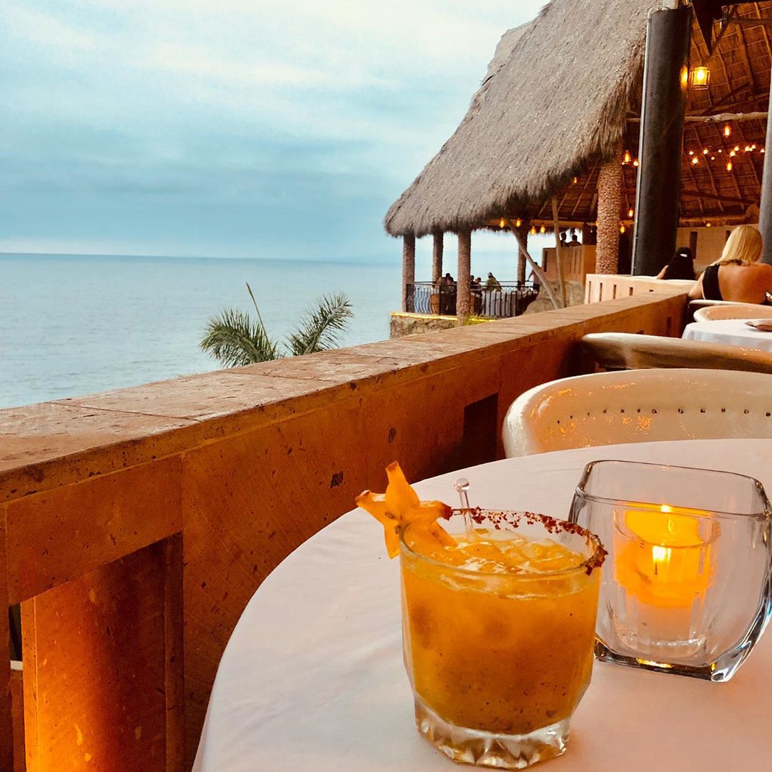 Cocktail on table overlooking ocean. 
