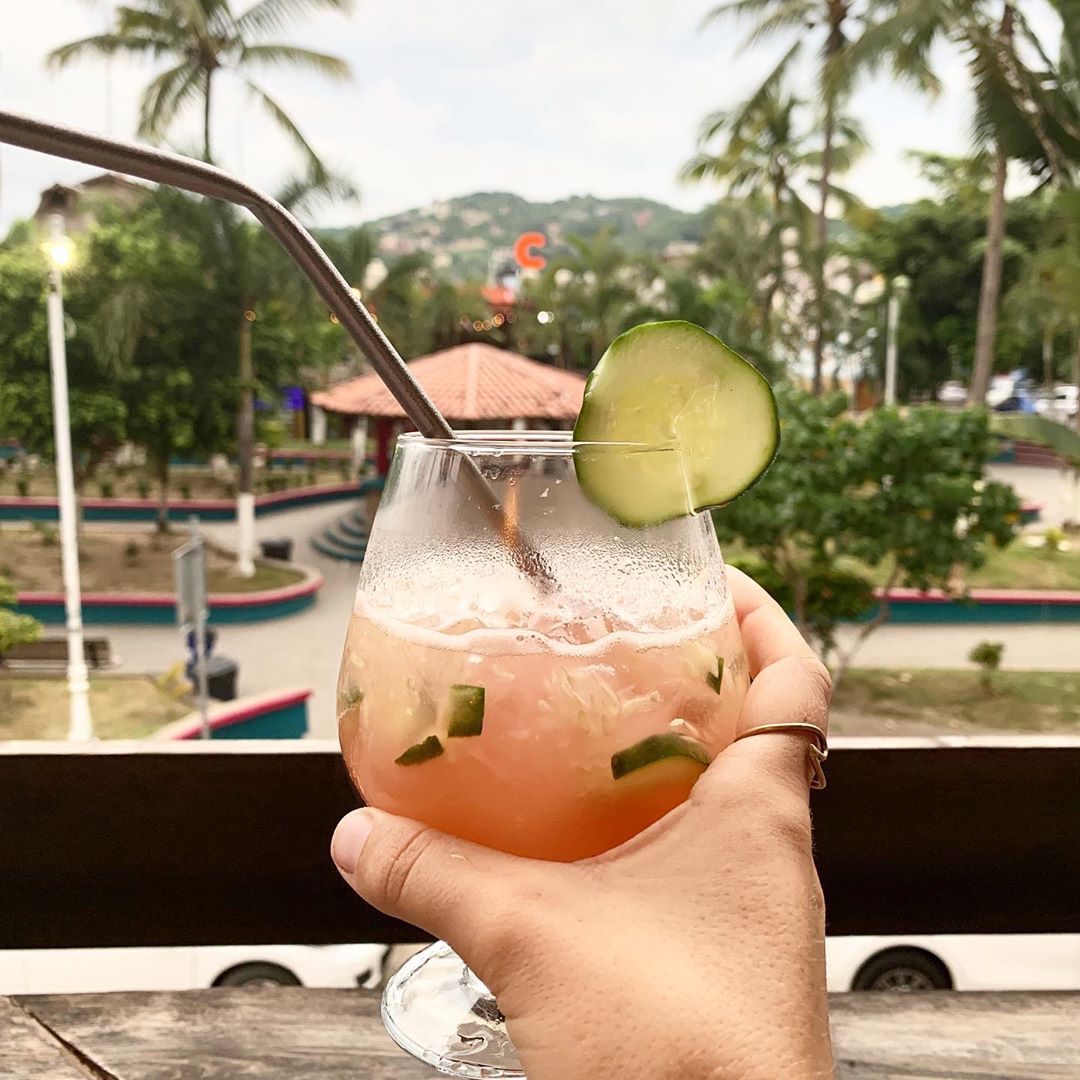 Cocktail with cucumbers with reusable straw in it. 