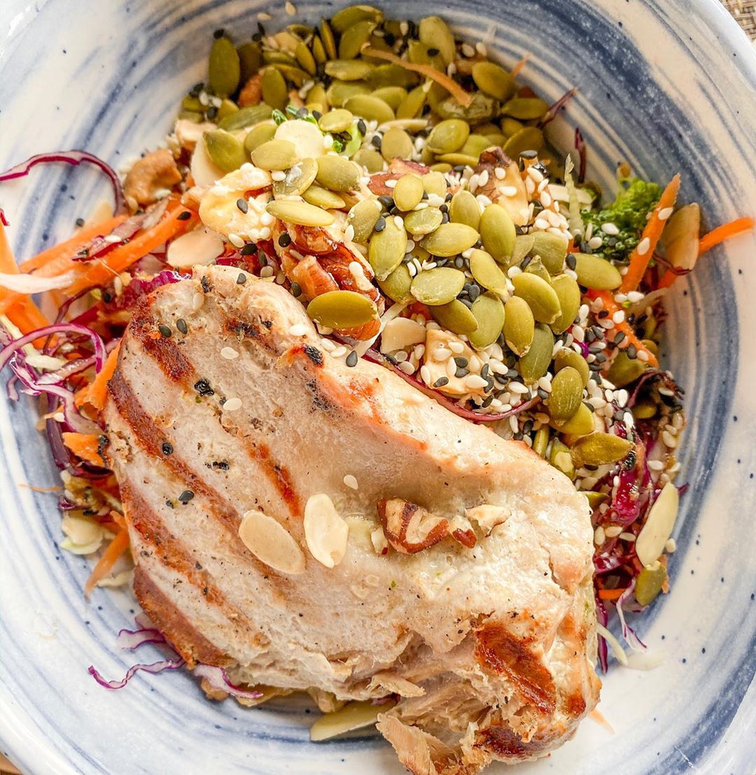 Mahi mahi fish on plate with other food. 